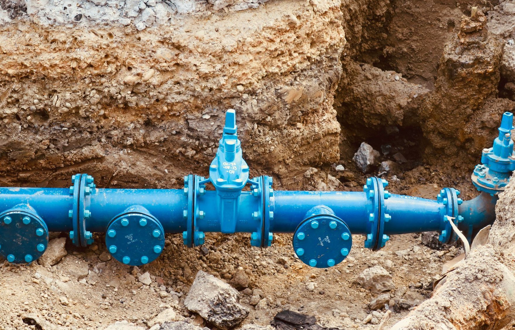 a blue pipe laying on top of a pile of dirt